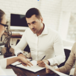 Husband and wife signing documents with a lawyer