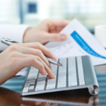 Woman’s hands on computer with tax paperwork